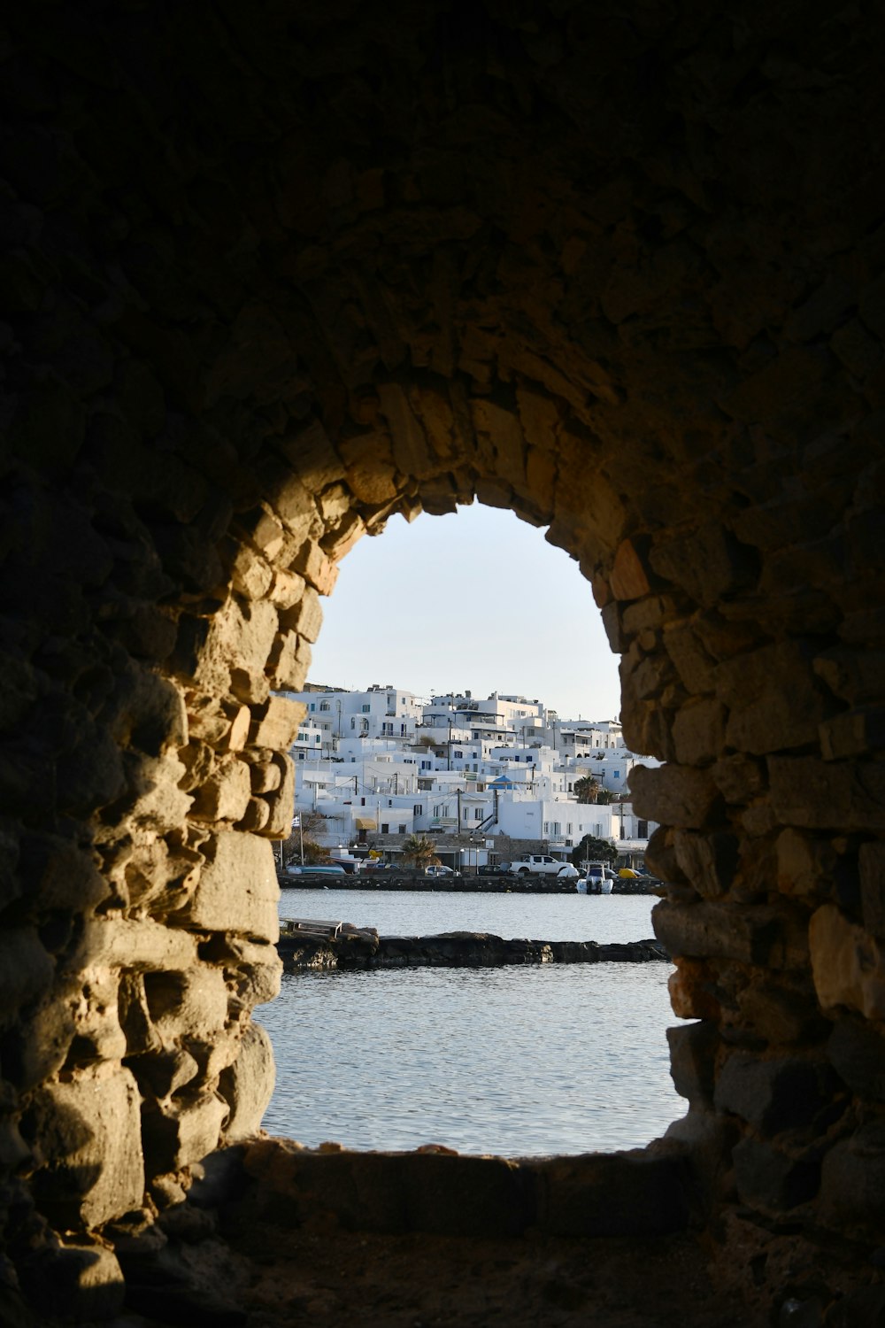 a view of a body of water through a stone archway