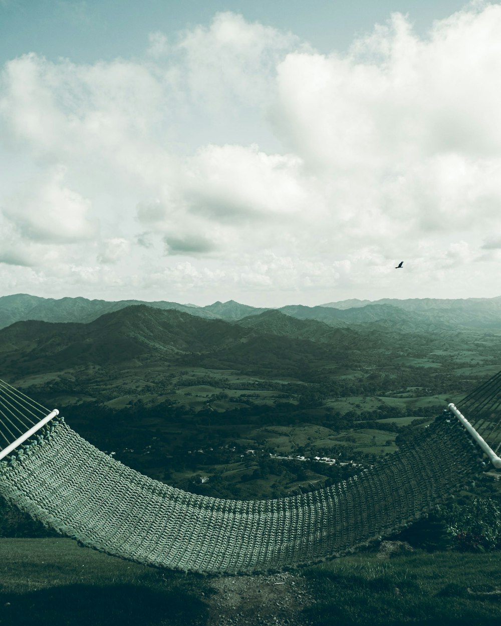 a hammock in a field with mountains in the background