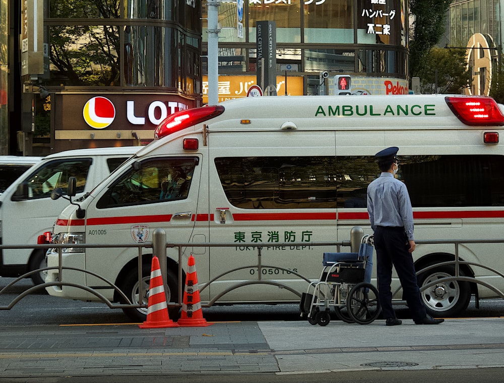 a man standing next to an ambulance on a city street