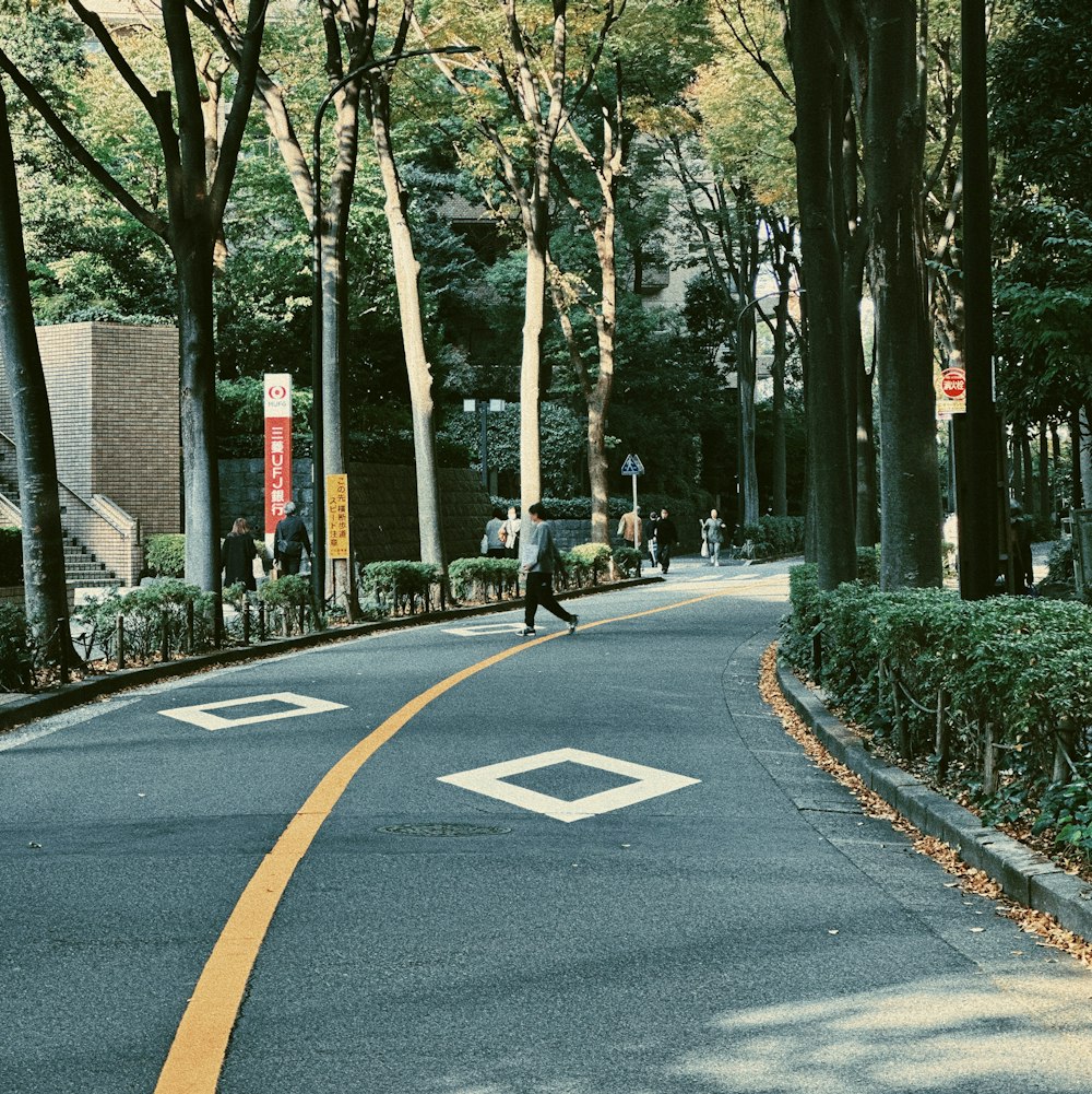 a person riding a skateboard down a tree lined street