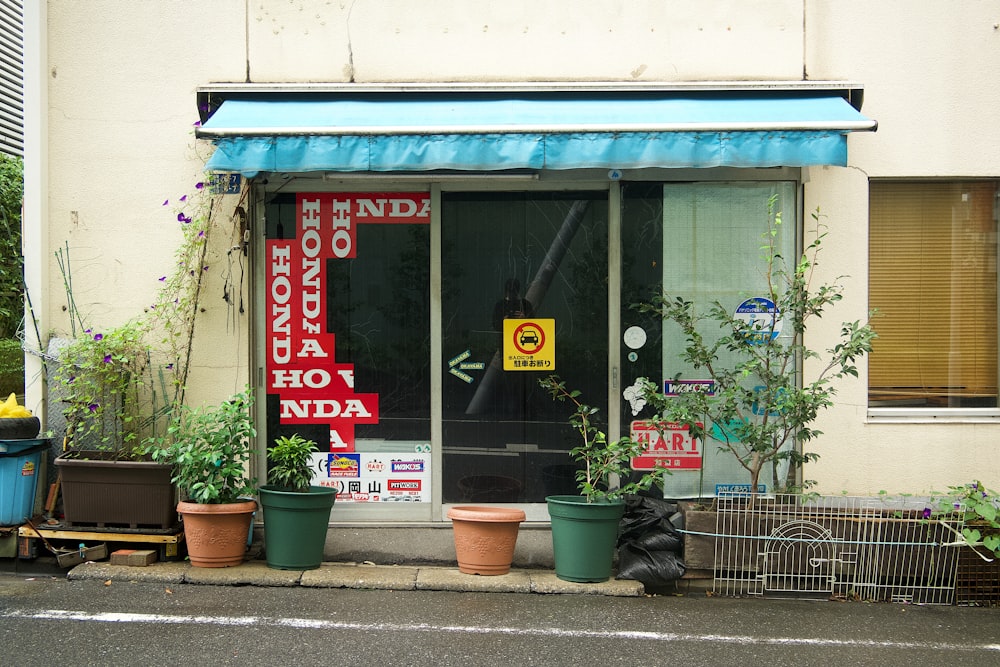 una fachada de tienda con plantas en macetas frente a ella