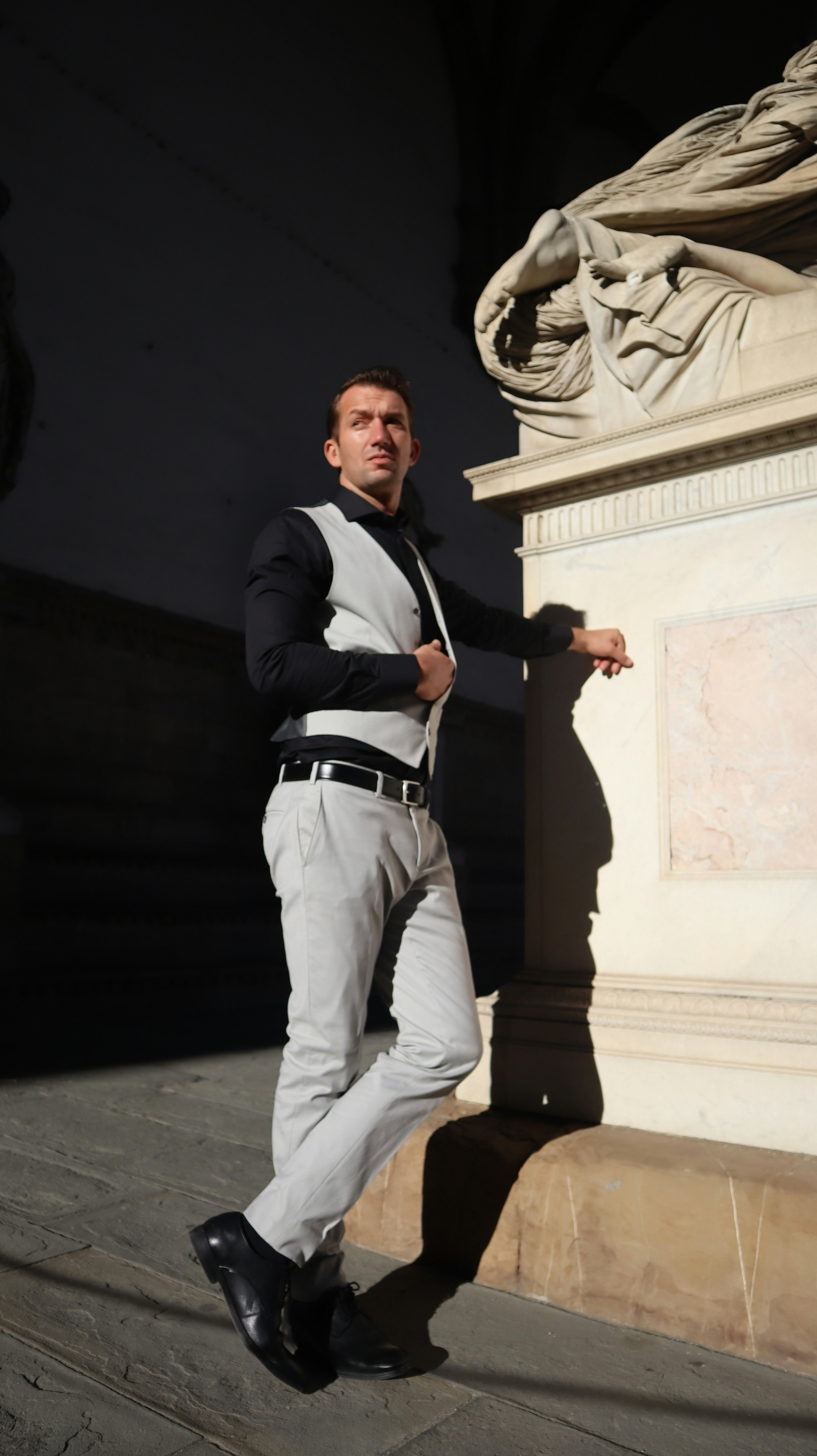 a man standing next to a statue in a building