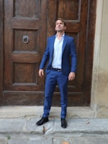 a man in a blue suit standing in front of a door