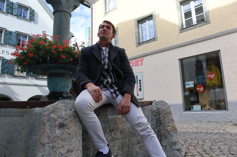 confident senior gentleman sitting near a heritage building