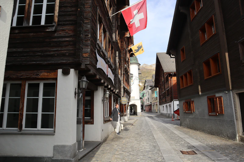 Una calle adoquinada con una bandera suiza ondeando al fondo, un destino de lujo