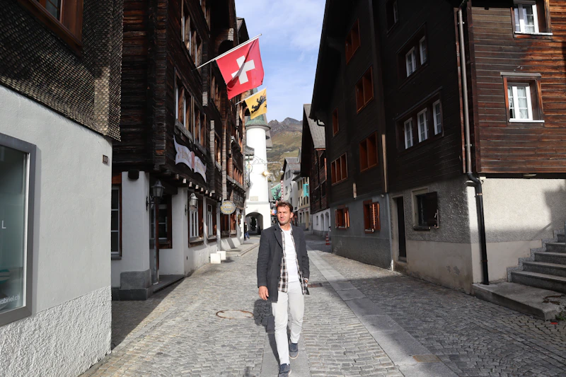 a man is walking down a cobblestone street