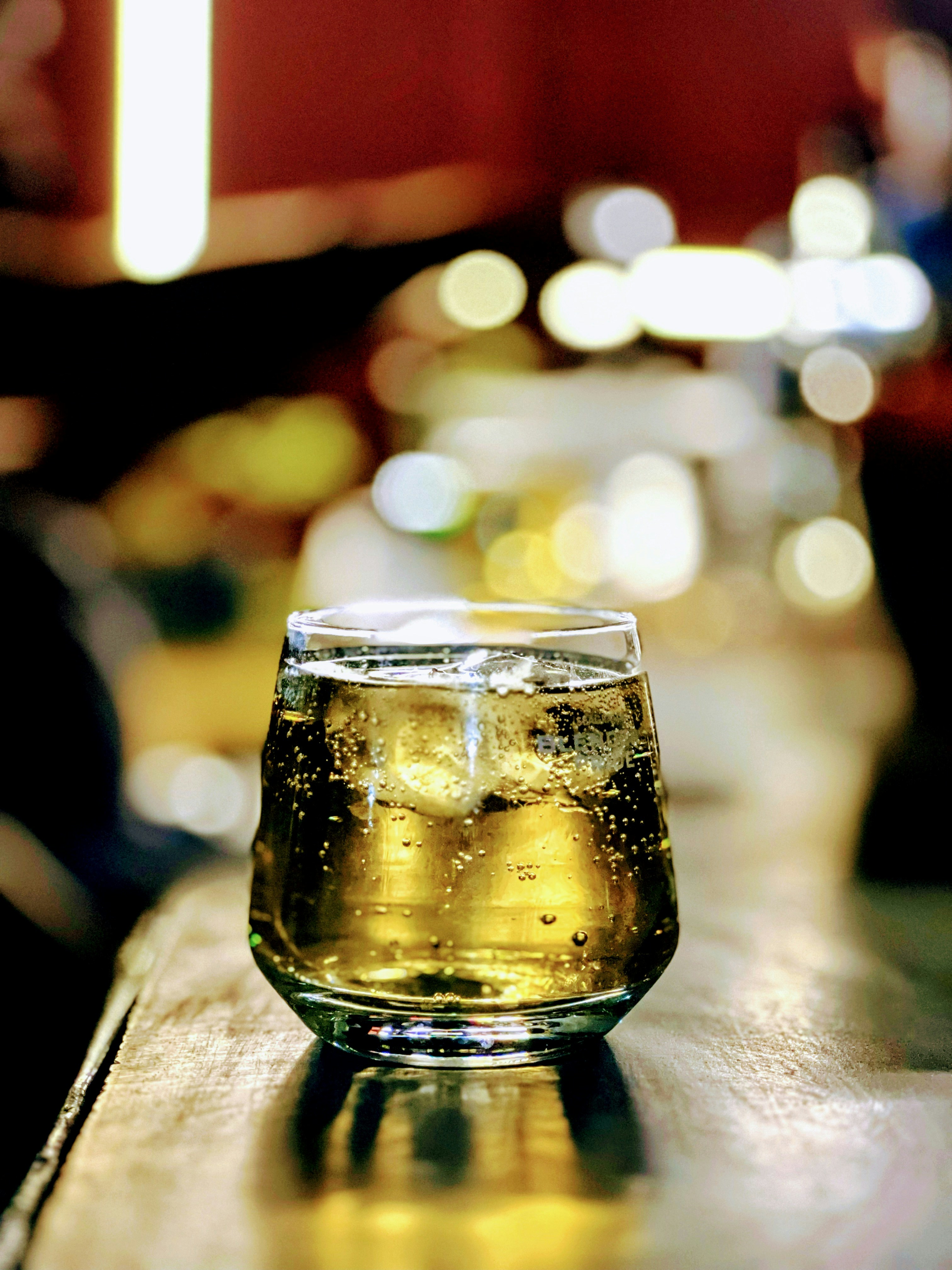 a glass of beer sitting on top of a wooden table
