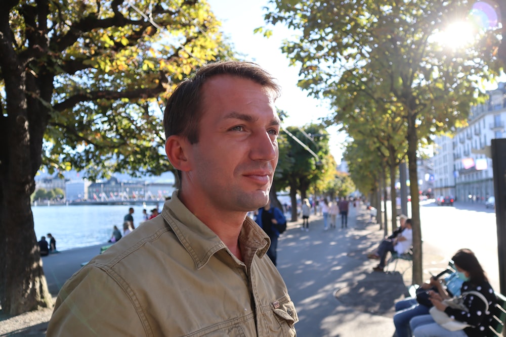 a man standing on the side of a street next to trees