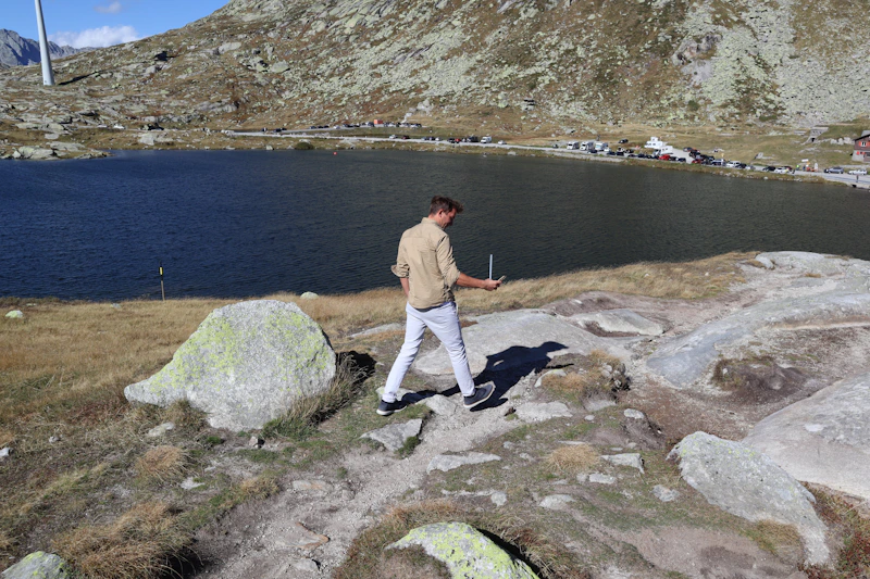 adventurous gay man overlooking a lakeside hillside
