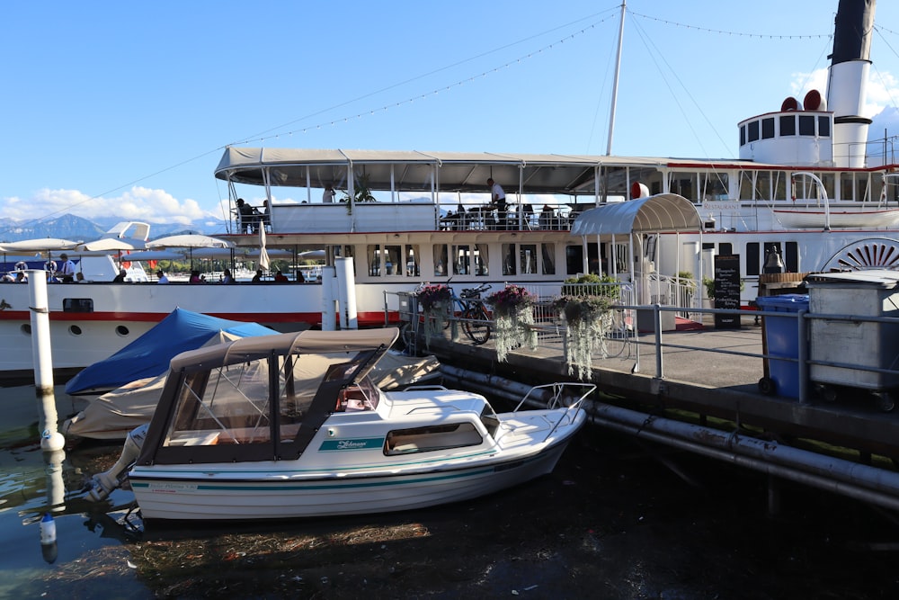 a boat docked at a pier with people on it