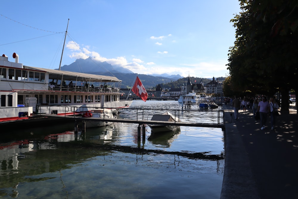 a boat docked at a pier with a flag on it