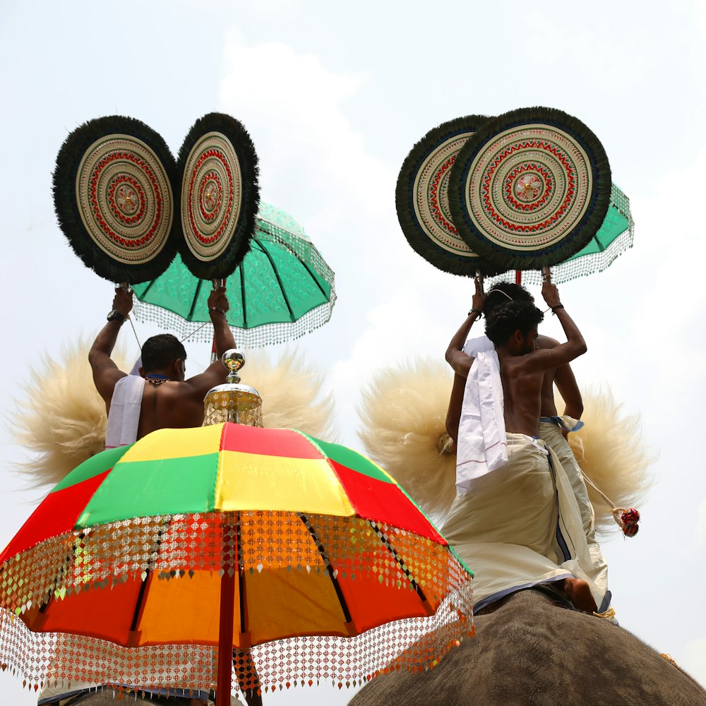 a couple of men riding on the back of an elephant