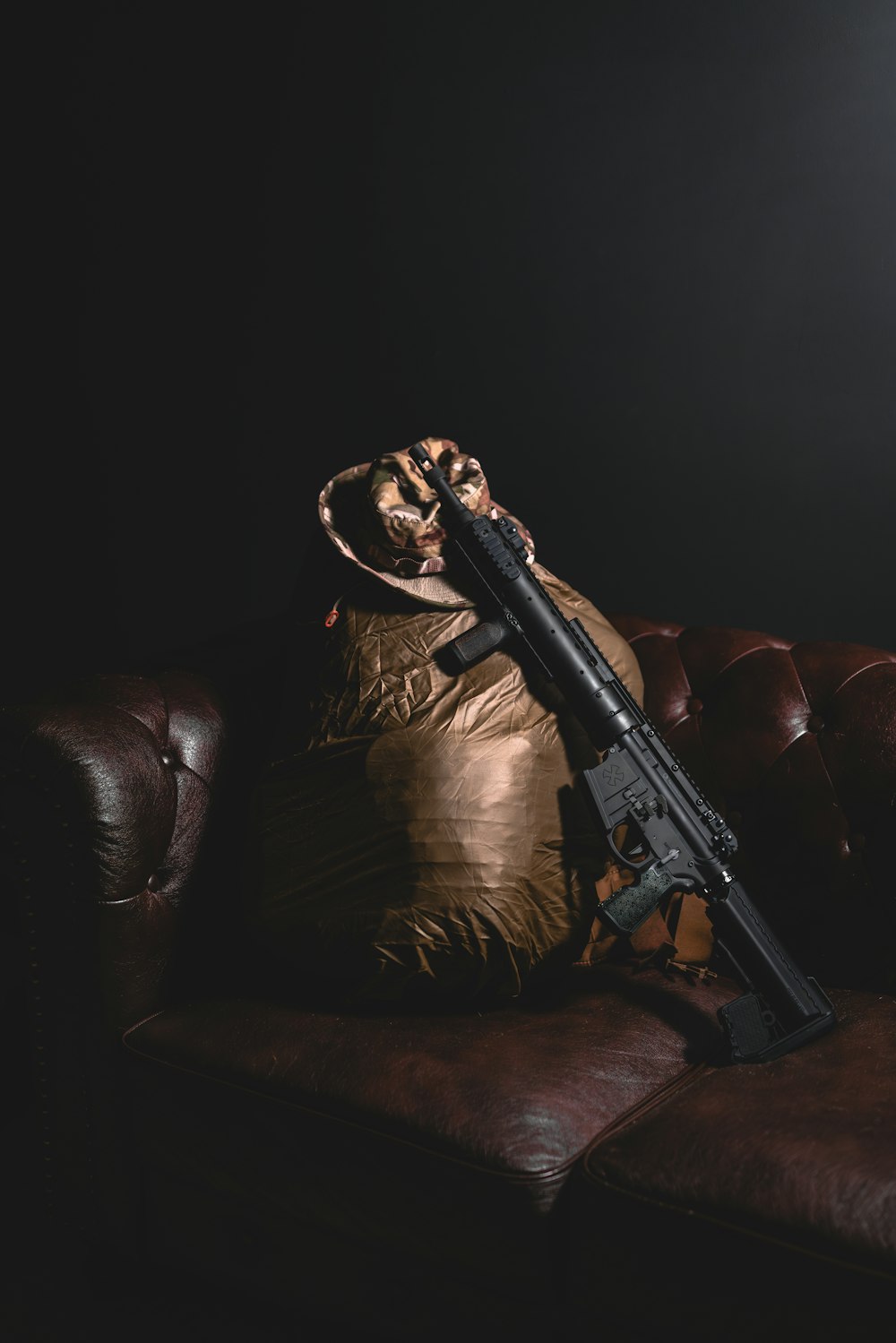 a gun laying on top of a pillow on a couch