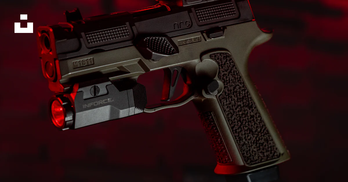 A close up of a gun with a red light in the background photo – Free ...