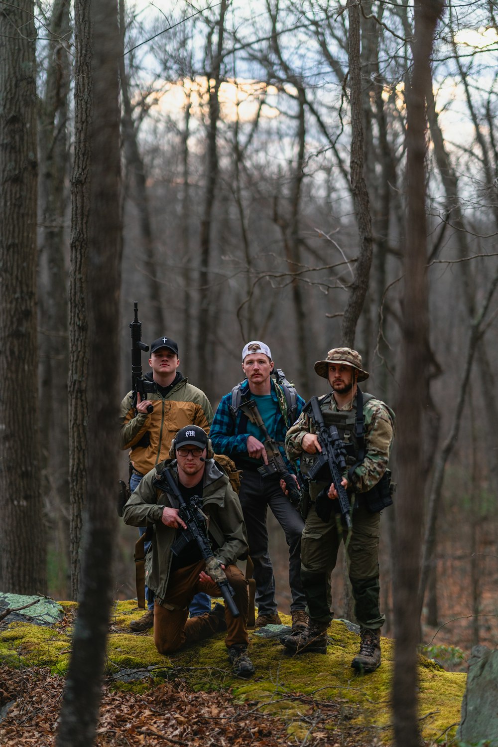 a group of men standing next to each other in the woods