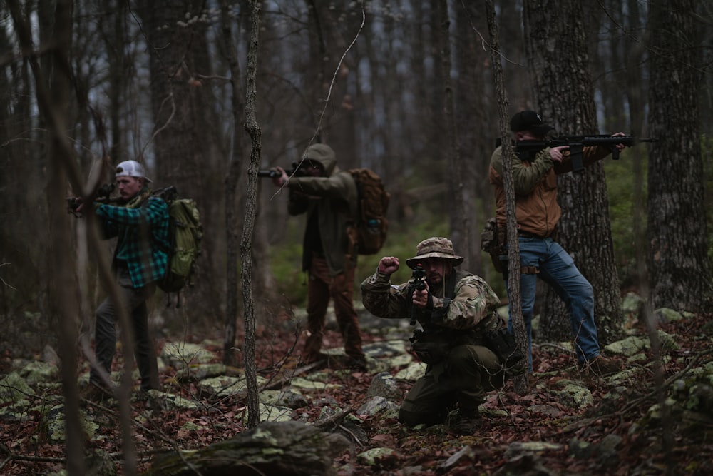 a group of men in the woods with guns