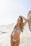 a woman in a bikini standing on a beach