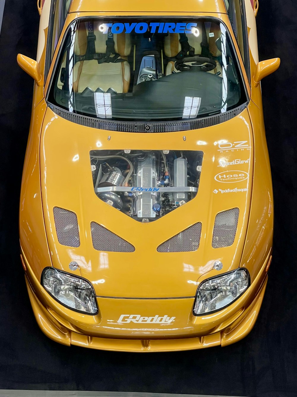 a close up of a yellow sports car on display