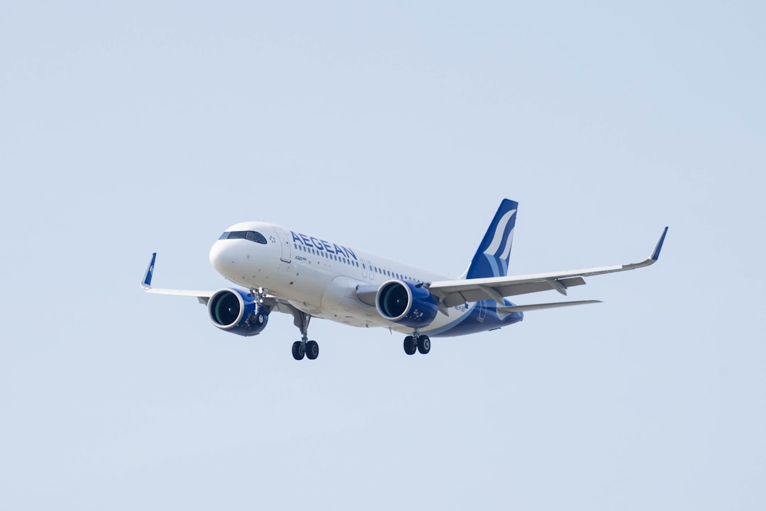 a large jetliner flying through a blue sky, Airliner of a Greek company landing with landing gear extracted.
