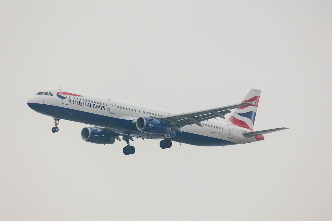 a large passenger jet flying through a gray sky, Airliner of an English company landing with cart extracted.