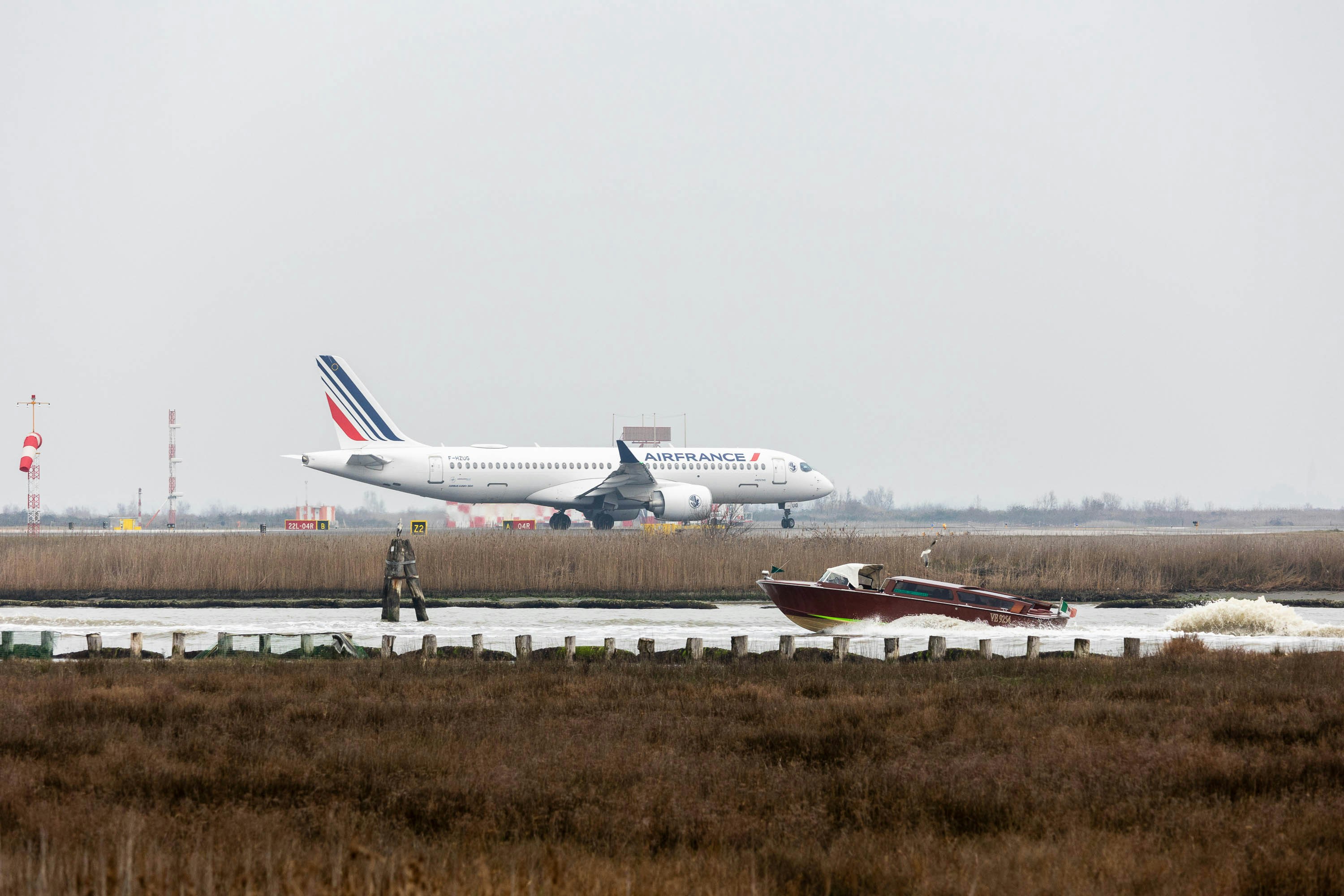 a large jetliner sitting on top of an airport runway, Airline of a French company landing with landing gear extracted.