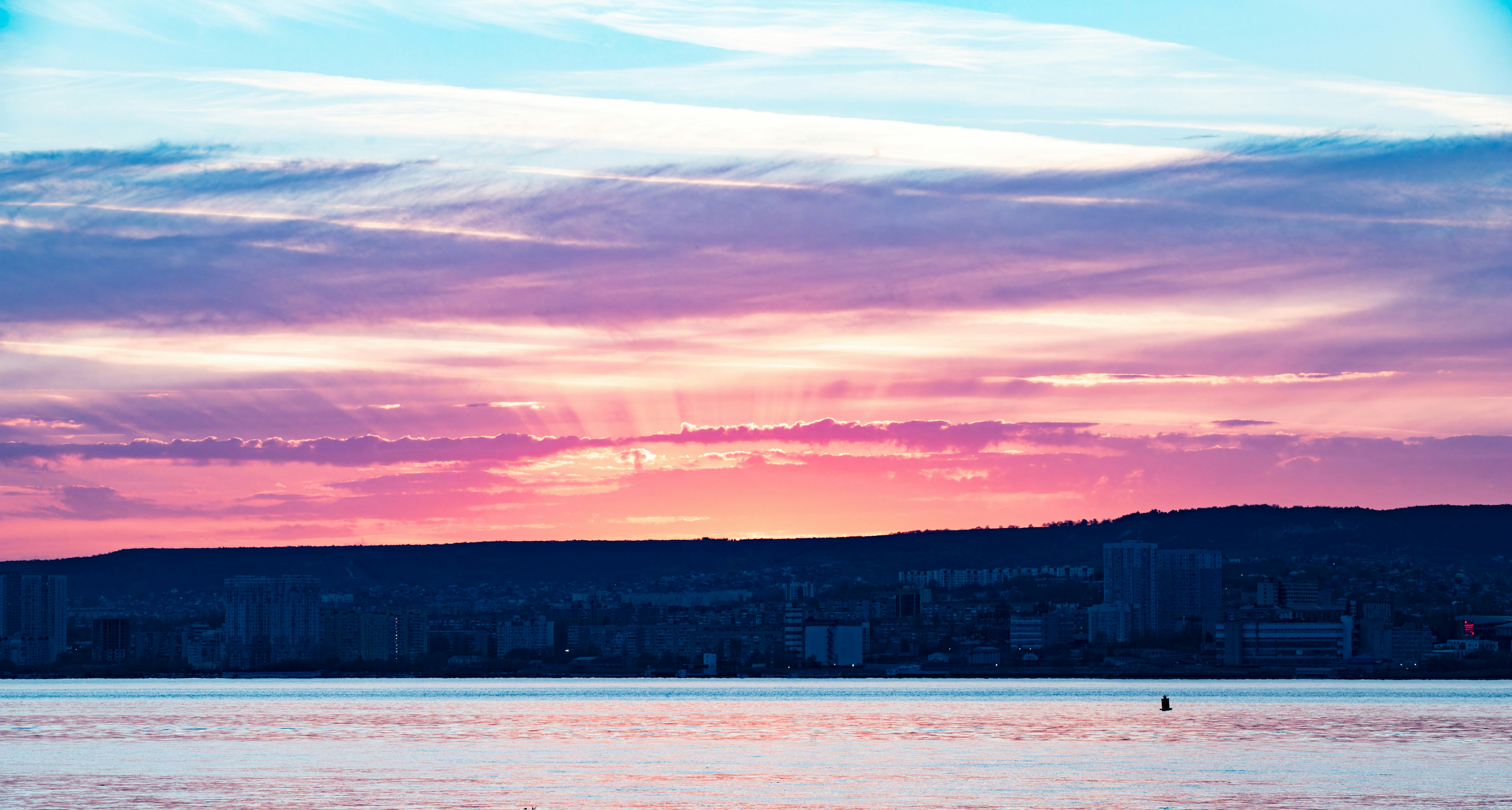 a large body of water with a city in the background