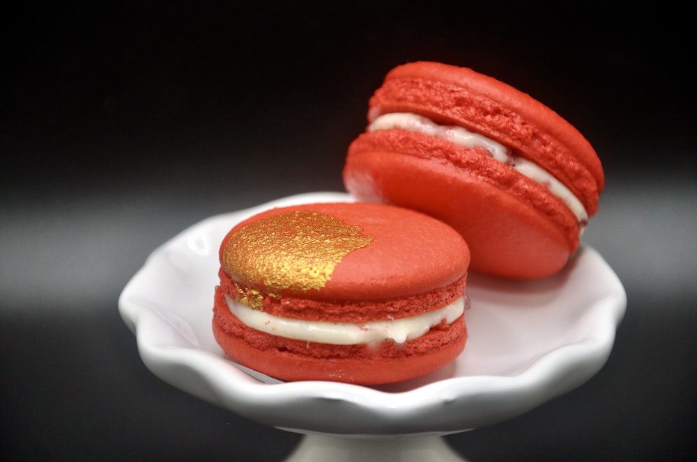 two red and white macaroons on a white plate