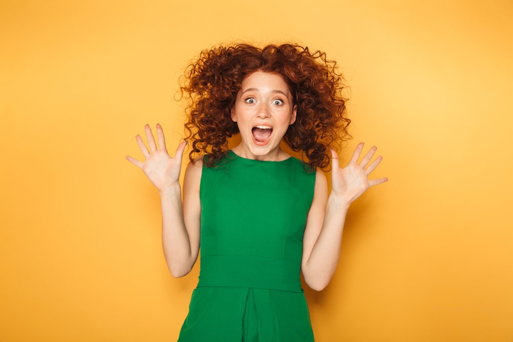 a woman in a green dress is making a surprised face