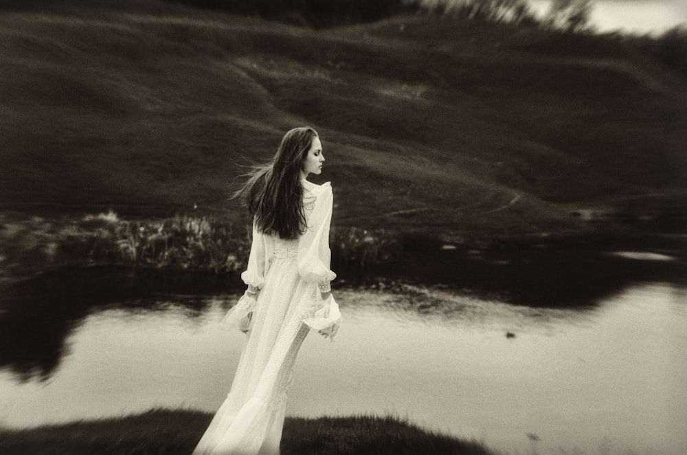 a woman standing in front of a body of water