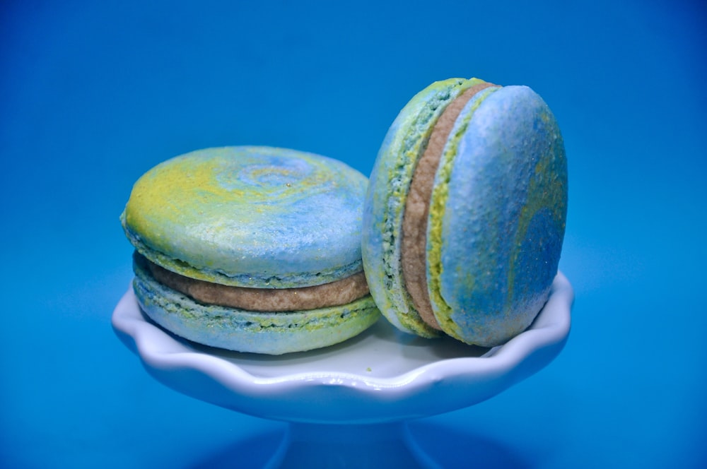 two macaroons on a plate on a blue background