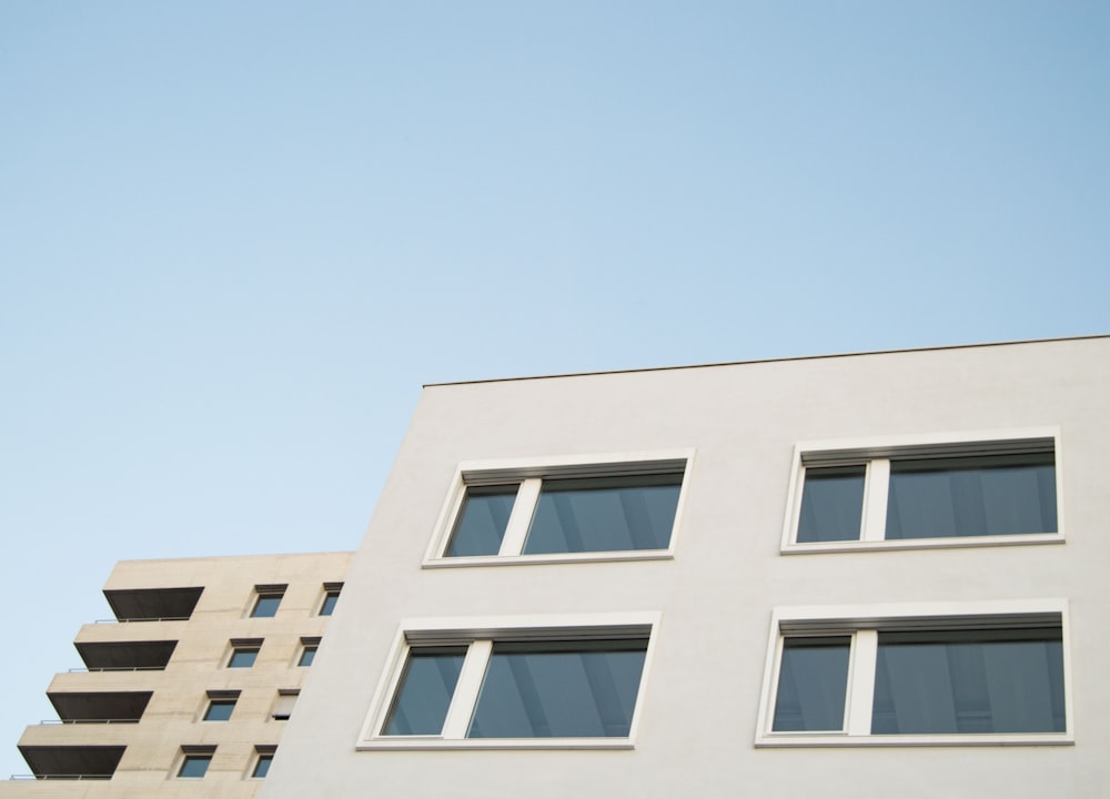 a white building with windows and a sky background