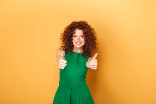 a woman in a green dress giving a thumbs up