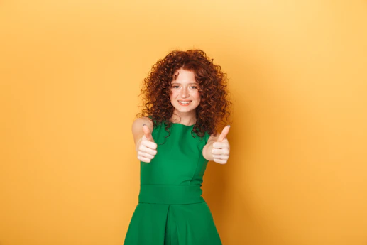 a woman in a green dress giving a thumbs up