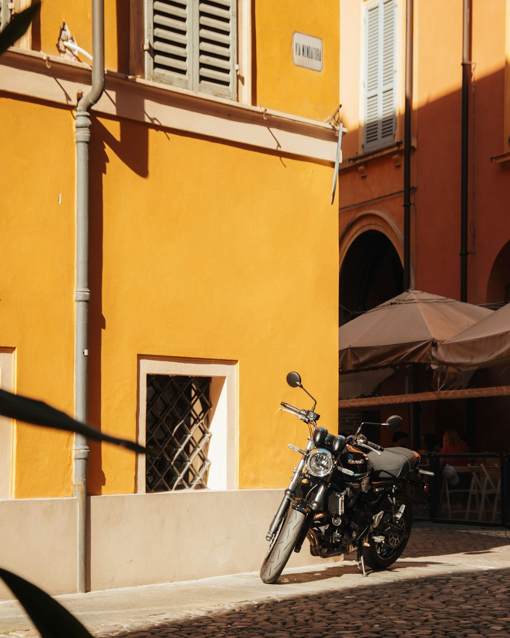 a motorcycle parked in front of a yellow building