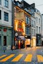 a city street with buildings and a yellow crosswalk