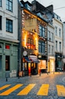 a city street with buildings and a yellow crosswalk