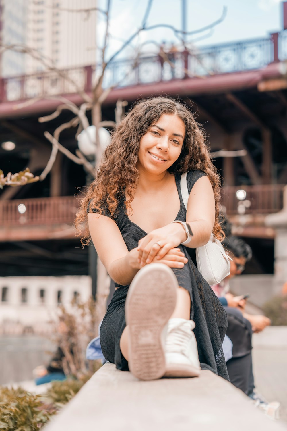 a woman sitting on top of a cement wall