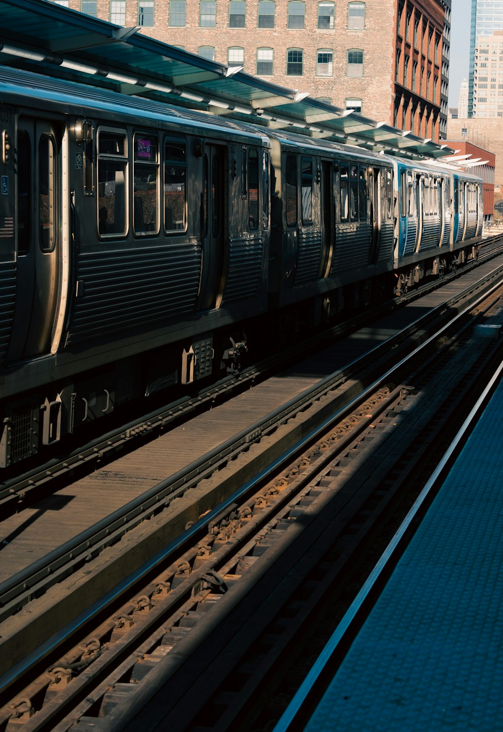 a train traveling down train tracks next to tall buildings