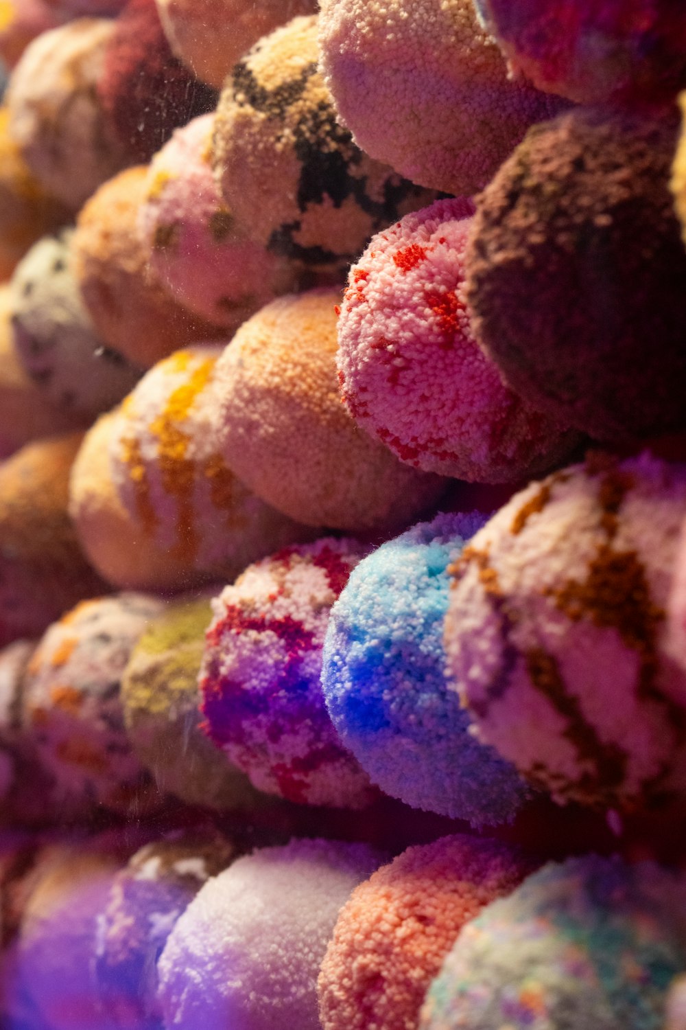 a bunch of doughnuts that are covered in colored powder