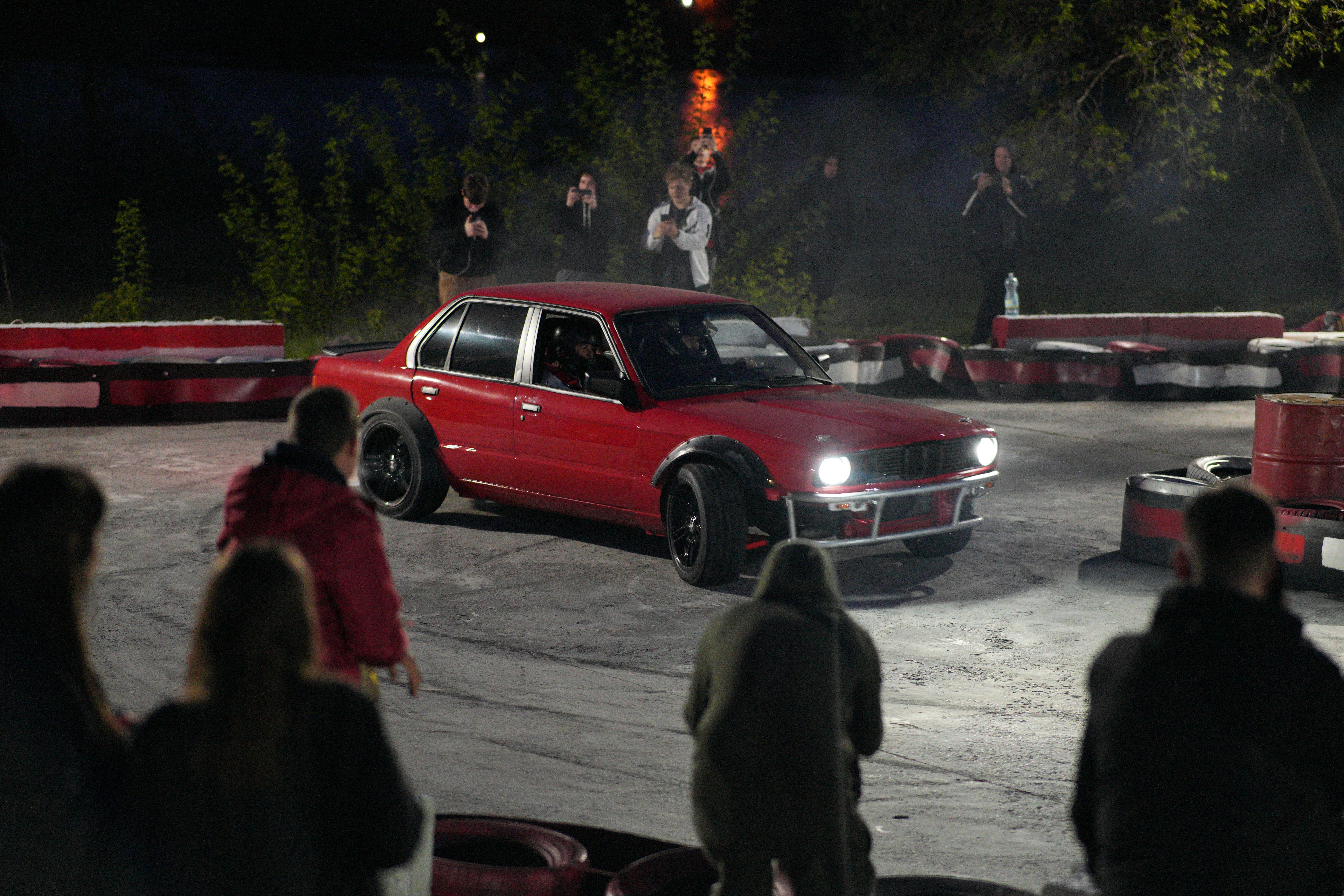 A red car driving around a track with people watching photo – Free ...