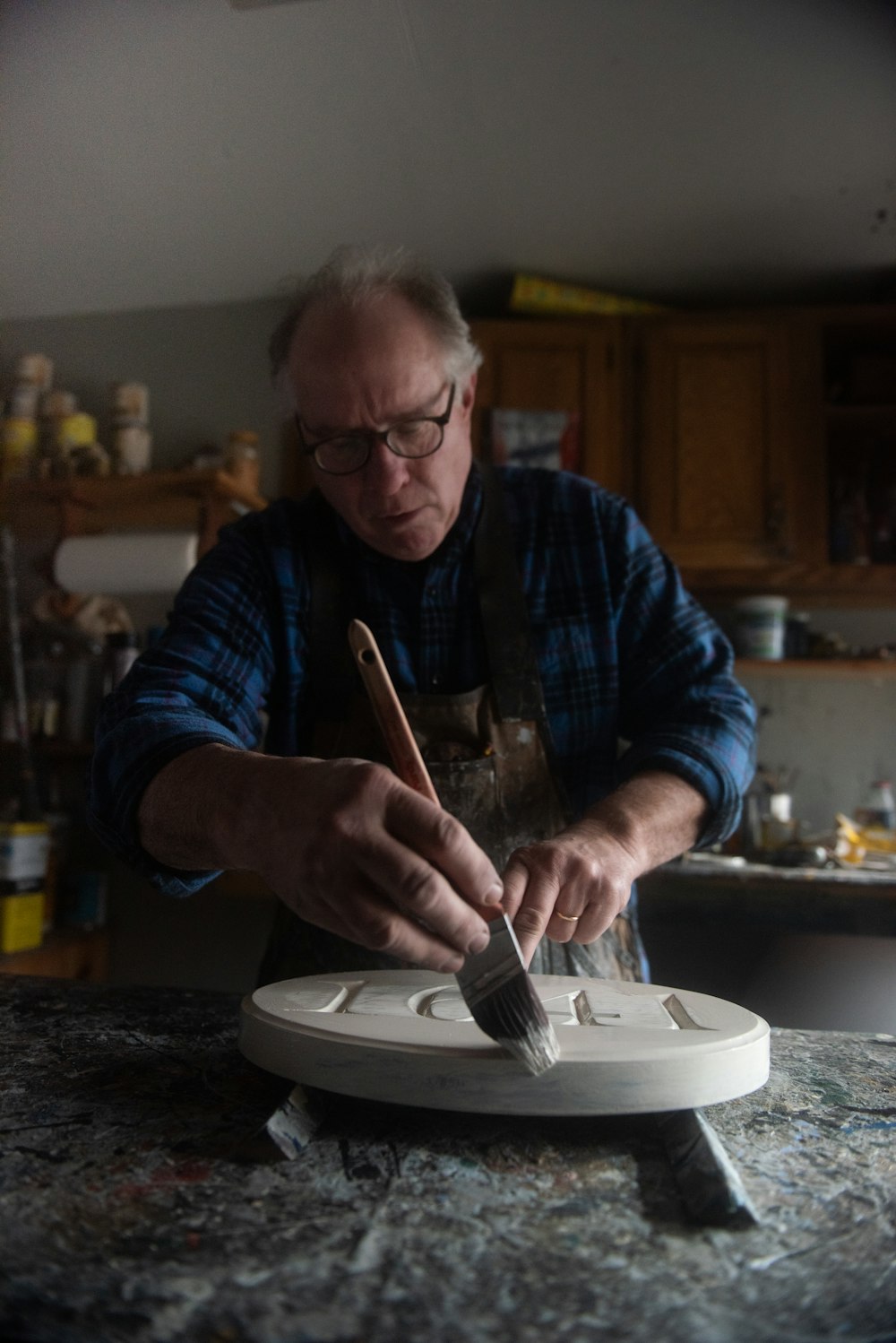 a man in a blue shirt is making a sculpture