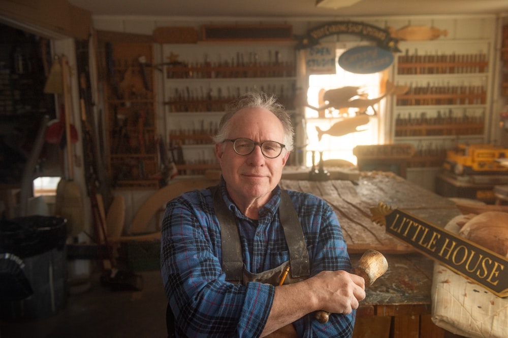 a man is holding a hammer in a shop