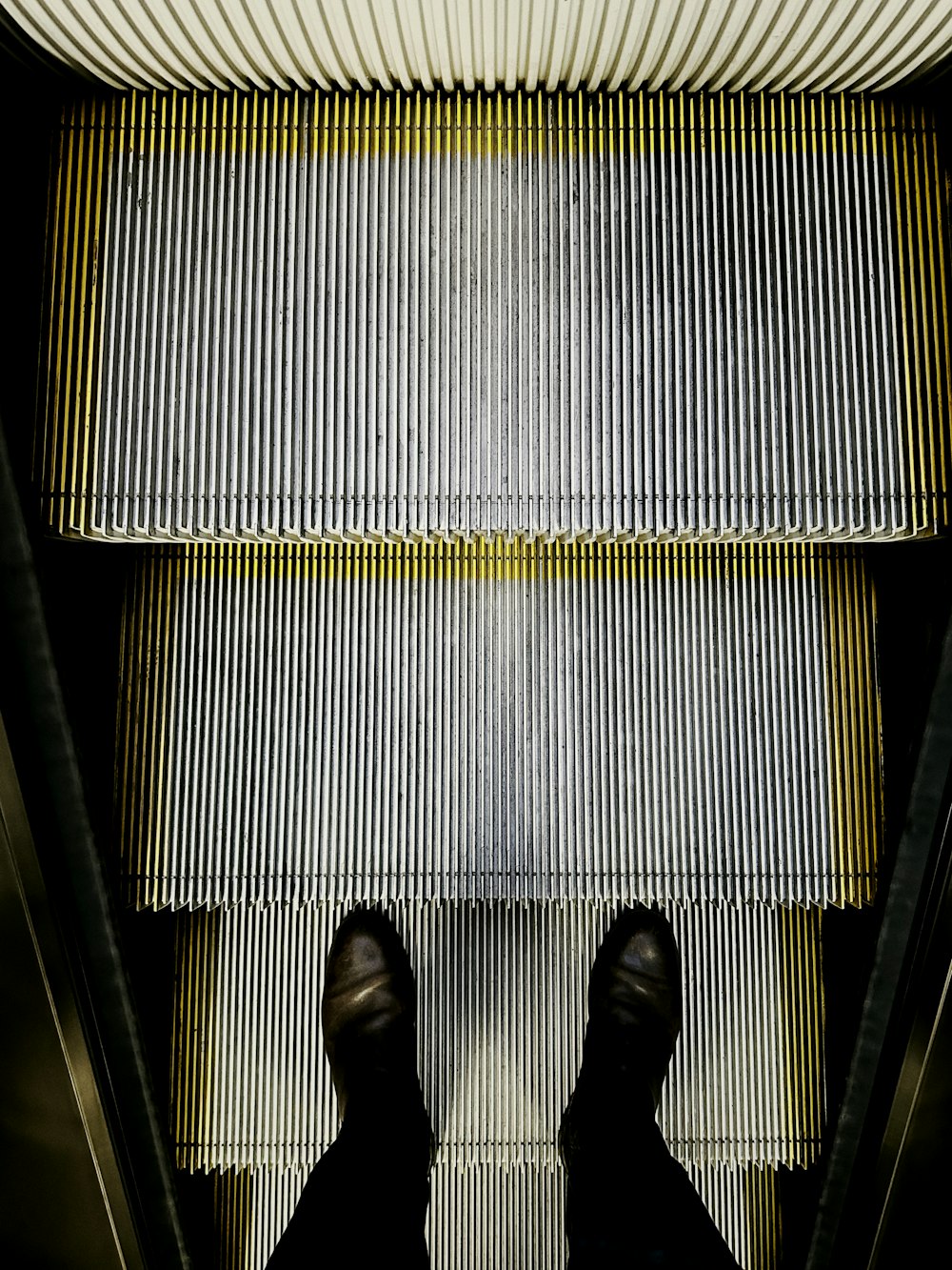a person standing on an escalator with their feet up