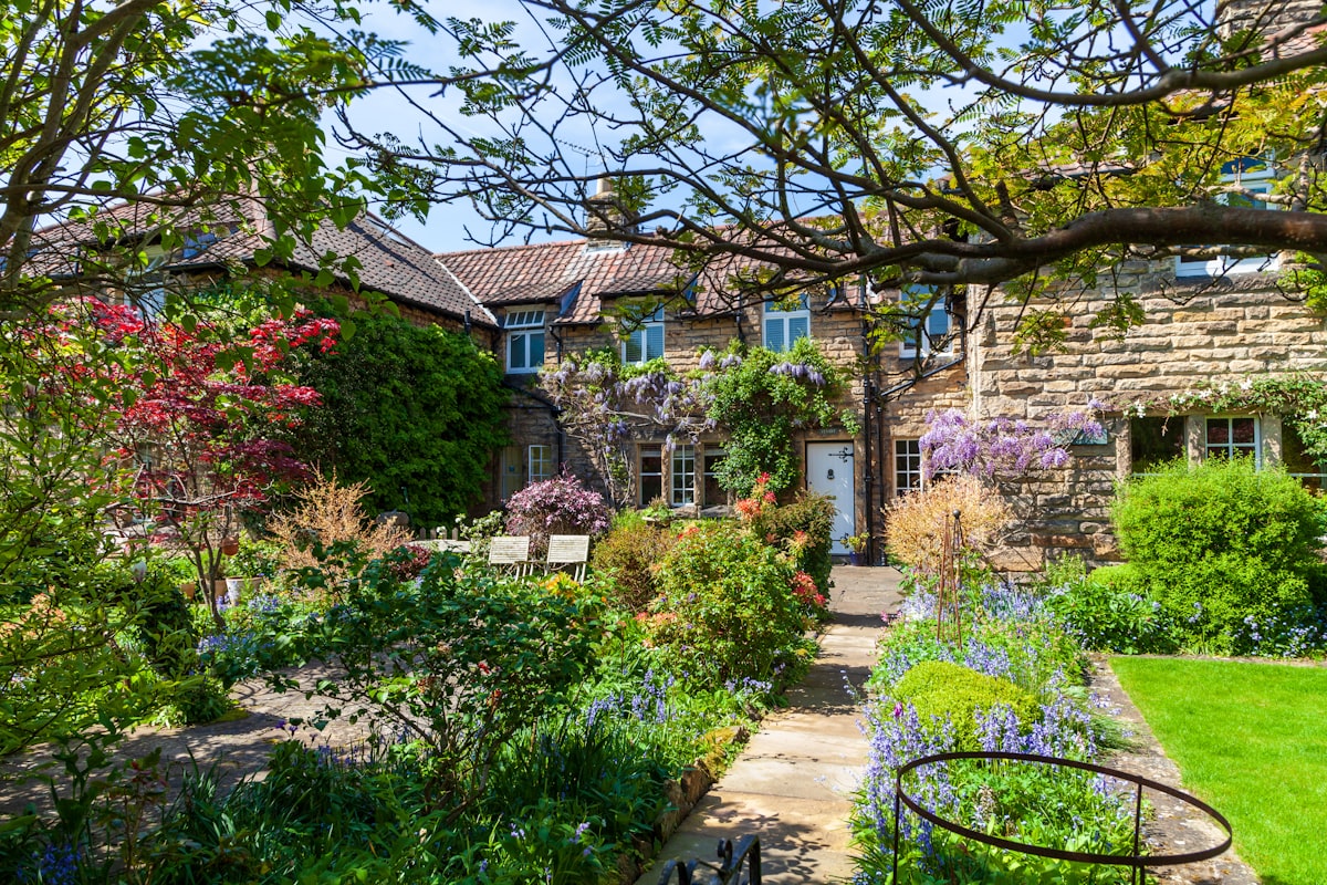 House with a beautiful garden in front showcasing spring flowers and curb appeal