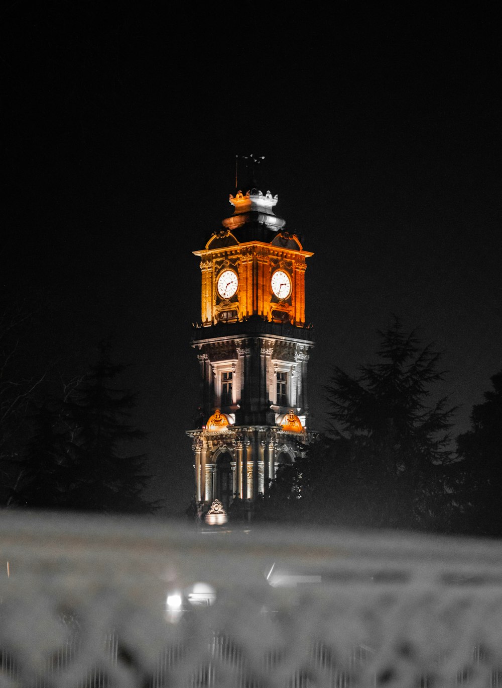 una grande torre dell'orologio illuminata di notte