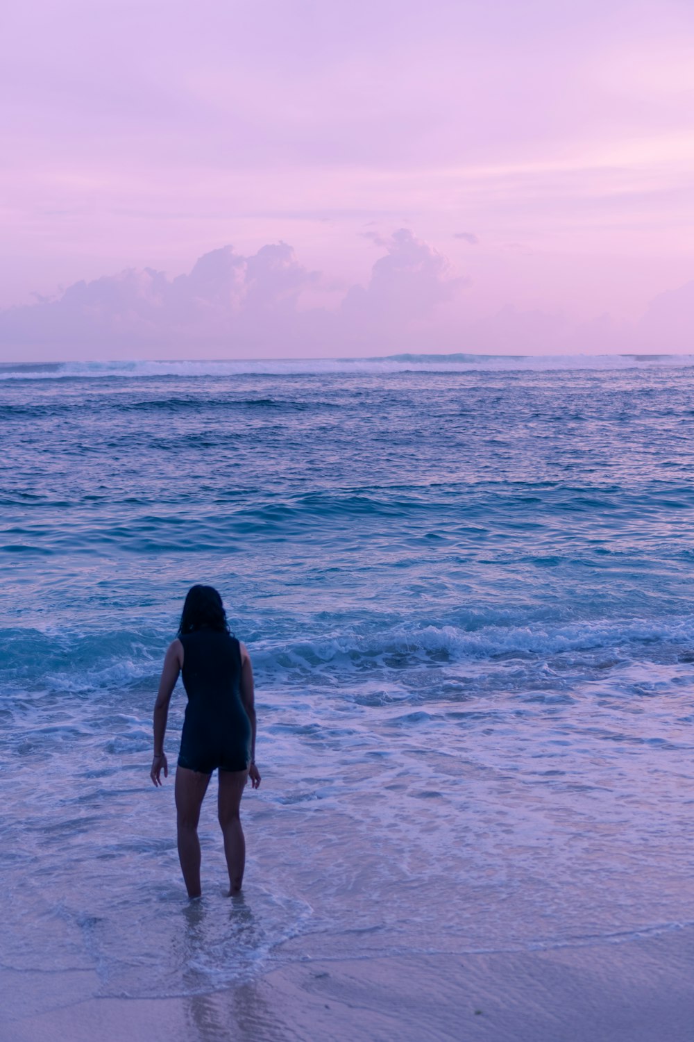 a woman standing in the water at the beach