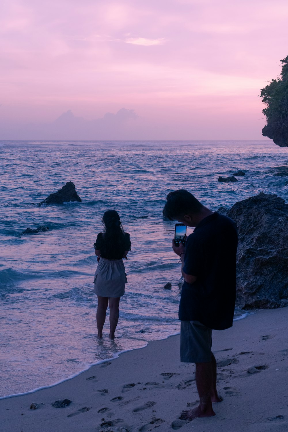 a couple of people standing on top of a beach