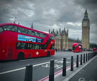 a red double decker bus driving down a street