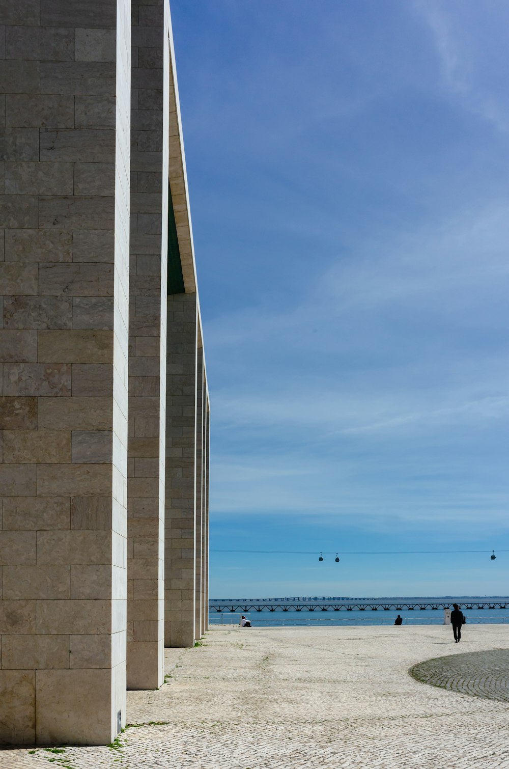 a couple of people standing on top of a sandy beach