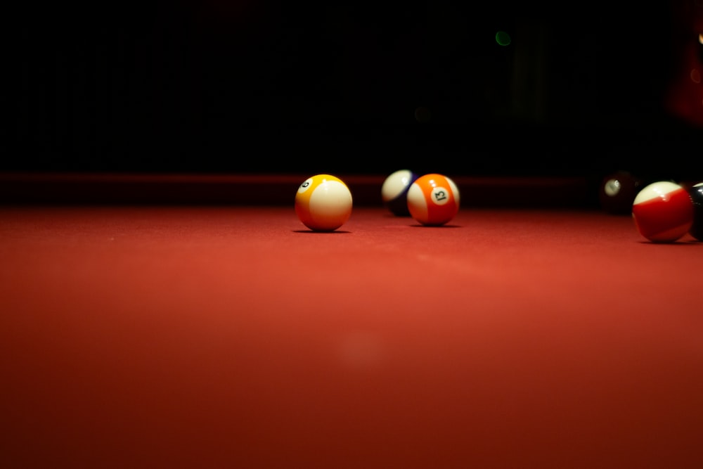 a red pool table with eight ball billiards